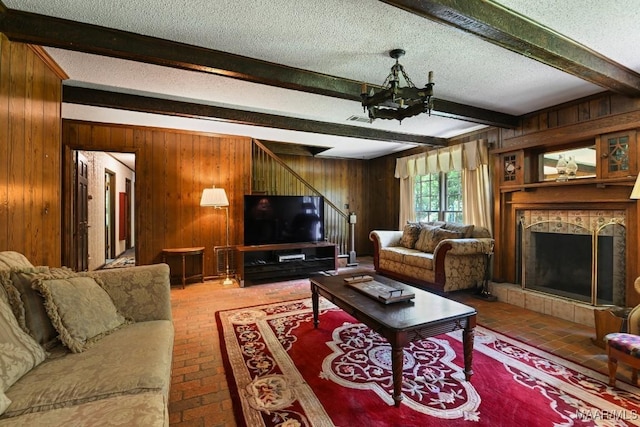 76 Willow Springs Rd, Wetumpka, AL 36093 - living area with brick floors, wood walls, beamed ceiling, stairs, and a textured ceiling