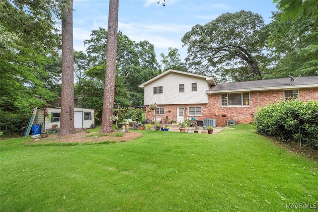 901 Green Forest Dr, Montgomery, AL 36109 - back of property with brick siding, a lawn, an outdoor structure, and view of scattered trees