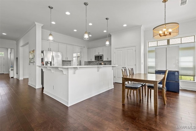 8326 Sunrise Loop, Montgomery, AL 36116 - kitchen featuring stainless steel appliances, crown molding, light countertops, a breakfast bar area, and a chandelier