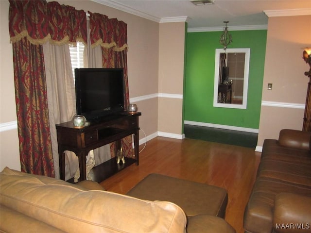 living area with wood finished floors and ornamental molding