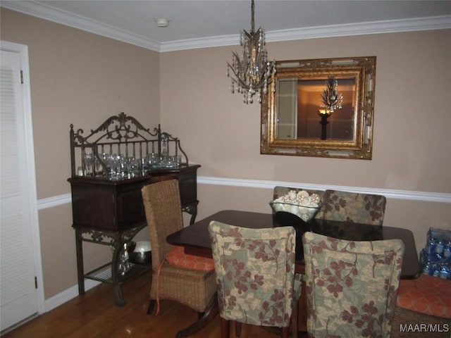 dining room with a chandelier, wood finished floors, and crown molding