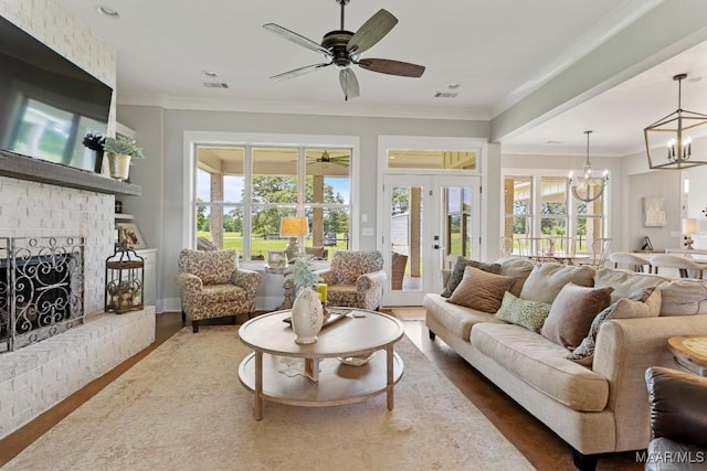 493 Lake Ridge Rd, Hope Hull, AL 36043 - living room with ornamental molding, ceiling fan, a chandelier, a brick fireplace, and wood finished floors