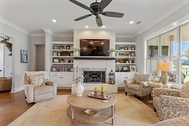 493 Lake Ridge Rd, Hope Hull, AL 36043 - living area with built in shelves, ceiling fan, crown molding, a brick fireplace, and recessed lighting