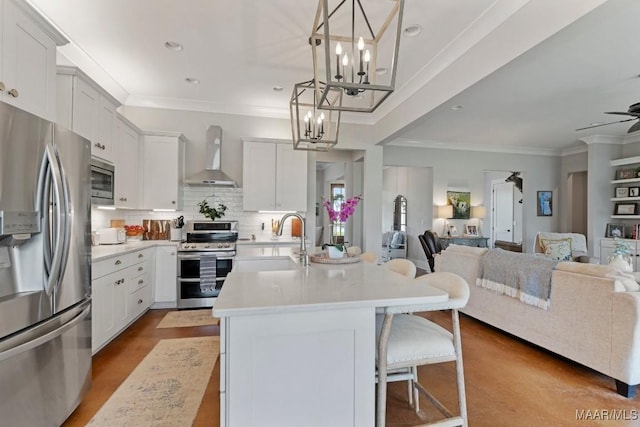 493 Lake Ridge Rd, Hope Hull, AL 36043 - kitchen featuring stainless steel appliances, wall chimney exhaust hood, open floor plan, a chandelier, and crown molding