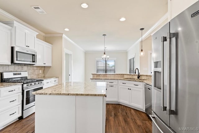 12 Crescent Ridge Ct, Deatsville, AL 36022 - kitchen with stainless steel appliances, a peninsula, dark wood-style flooring, crown molding, and white cabinets