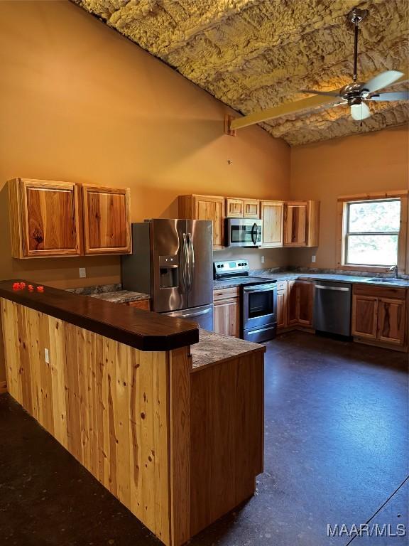 516 Jones Farm Rd, Camden, AL 36726 - kitchen with stainless steel appliances, ceiling fan, a towering ceiling, a peninsula, and dark countertops