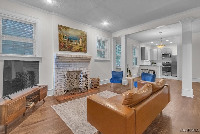 844 E Edgemont Ave, Montgomery, AL 36111 - living area featuring a brick fireplace, ornate columns, ornamental molding, light wood-style floors, and recessed lighting