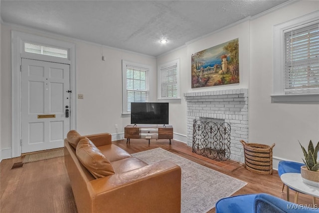 844 E Edgemont Ave, Montgomery, AL 36111 - living area featuring wood finished floors, ornamental molding, a textured ceiling, and a brick fireplace