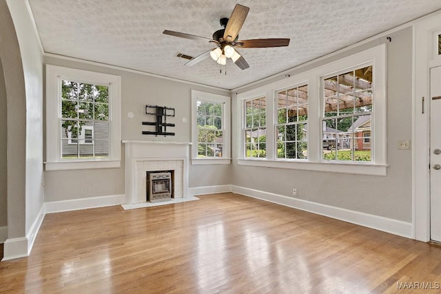 102 Vonora Ave, Montgomery, AL 36107 - unfurnished living room with a tile fireplace, light wood-style floors, a textured ceiling, and a ceiling fan