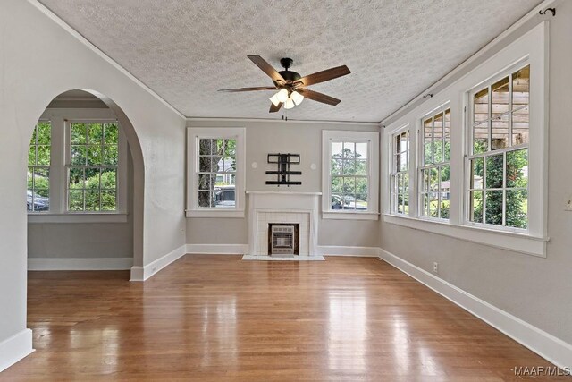 102 Vonora Ave, Montgomery, AL 36107 - unfurnished living room with wood finished floors, ceiling fan, crown molding, a fireplace, and a textured ceiling