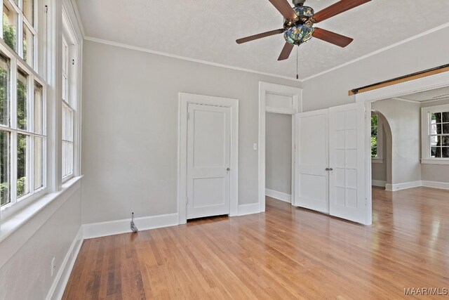 102 Vonora Ave, Montgomery, AL 36107 - empty room featuring arched walkways, a ceiling fan, light wood-style flooring, and crown molding