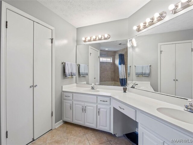 7117 Stamford Ct, Montgomery, AL 36117 - bathroom with double vanity, tiled shower, a closet, a textured ceiling, and tile patterned floors