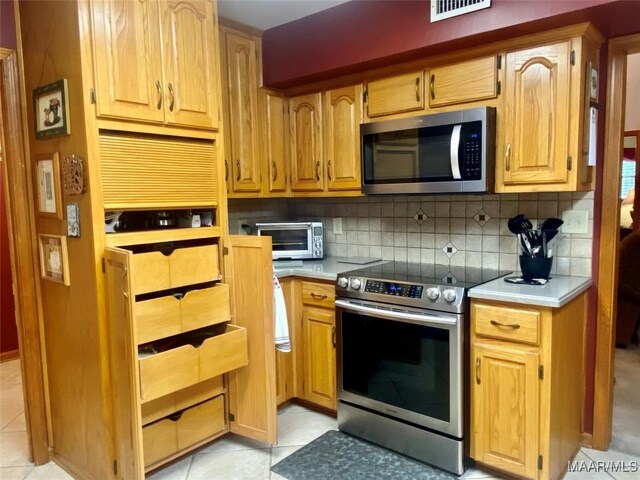 5240 Airport Rd, Millbrook, AL 36054 - kitchen with stainless steel appliances, light countertops, decorative backsplash, and light tile patterned floors