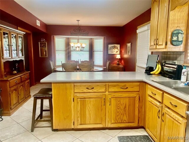 5240 Airport Rd, Millbrook, AL 36054 - kitchen featuring a peninsula, light countertops, a chandelier, and light tile patterned floors