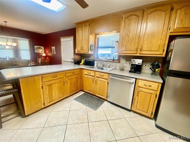5240 Airport Rd, Millbrook, AL 36054 - kitchen with stainless steel appliances, a peninsula, light countertops, tasteful backsplash, and a ceiling fan