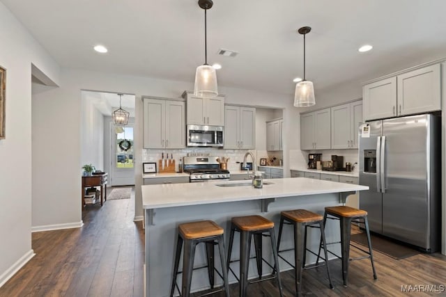 904 Hedgefield Way, Prattville, AL 36066 - kitchen with stainless steel appliances, tasteful backsplash, light countertops, dark wood-style floors, and a kitchen bar
