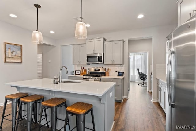 904 Hedgefield Way, Prattville, AL 36066 - kitchen featuring stainless steel appliances, light countertops, a breakfast bar area, dark wood-style flooring, and backsplash