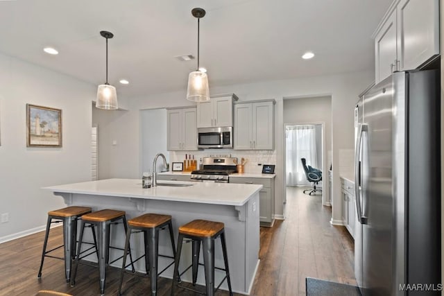 904 Hedgefield Way, Prattville, AL 36066 - kitchen with stainless steel appliances, light countertops, a kitchen bar, dark wood-type flooring, and recessed lighting