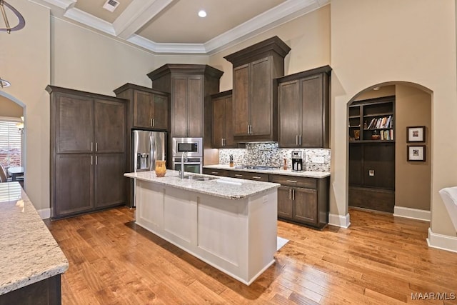 8612 Birchwood Ct, Montgomery, AL 36116 - kitchen featuring appliances with stainless steel finishes, arched walkways, dark brown cabinets, a high ceiling, and ornamental molding
