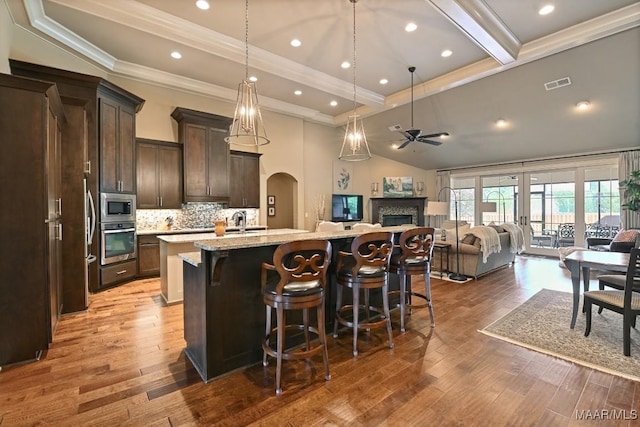 8612 Birchwood Ct, Montgomery, AL 36116 - kitchen with stainless steel appliances, crown molding, a fireplace, open floor plan, and a ceiling fan