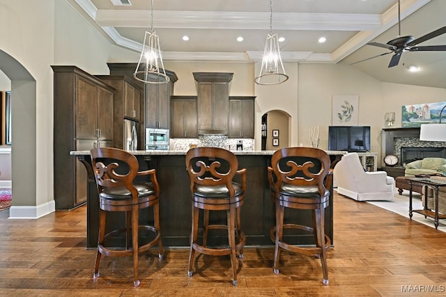 8612 Birchwood Ct, Montgomery, AL 36116 - kitchen with arched walkways, stainless steel appliances, dark brown cabinets, backsplash, and beamed ceiling