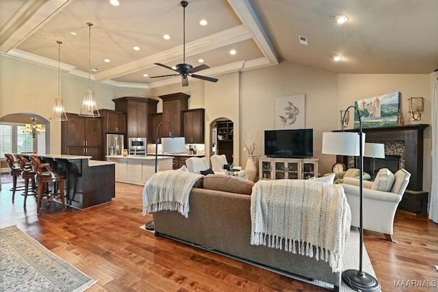 8612 Birchwood Ct, Montgomery, AL 36116 - living room with arched walkways, a chandelier, wood finished floors, a ceiling fan, and crown molding