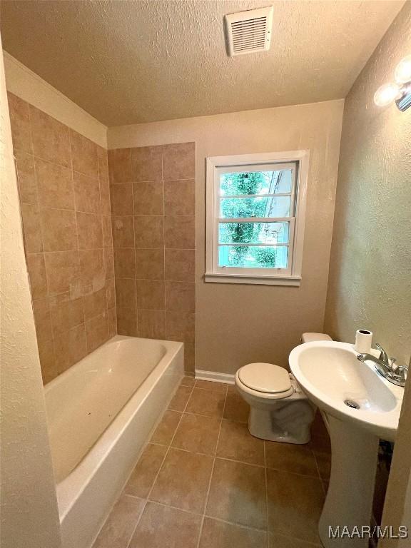 2441 Spruce Curv, Montgomery, AL 36107 - full bathroom with tile patterned floors, a bath, a textured ceiling, a textured wall, and a shower