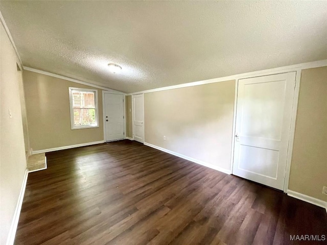 2441 Spruce Curv, Montgomery, AL 36107 - empty room with dark wood-style flooring, a textured ceiling, vaulted ceiling, and crown molding