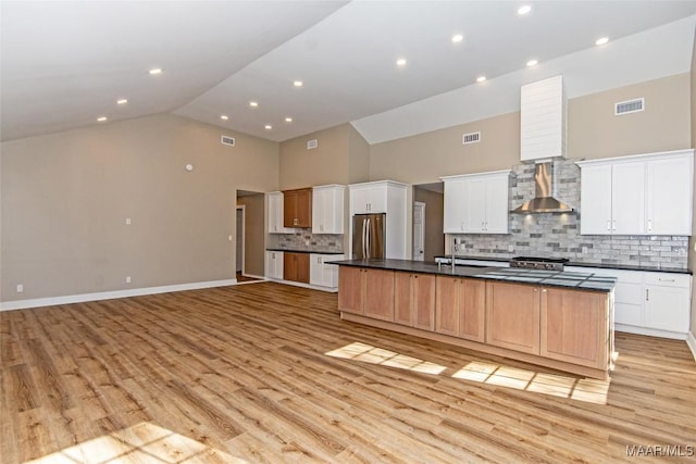 11056 Central Plank Rd, Eclectic, AL 36024 - kitchen featuring wall chimney exhaust hood, freestanding refrigerator, high vaulted ceiling, dark countertops, and light wood-style floors