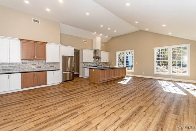 11056 Central Plank Rd, Eclectic, AL 36024 - kitchen with freestanding refrigerator, open floor plan, dark countertops, light wood-type flooring, and tasteful backsplash
