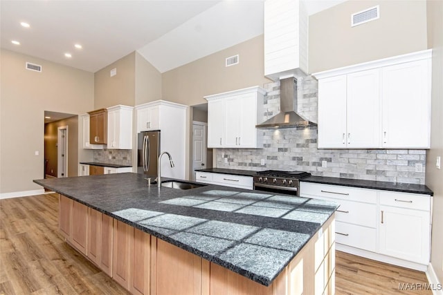 11056 Central Plank Rd, Eclectic, AL 36024 - kitchen featuring wall chimney exhaust hood, high vaulted ceiling, appliances with stainless steel finishes, dark countertops, and light wood finished floors