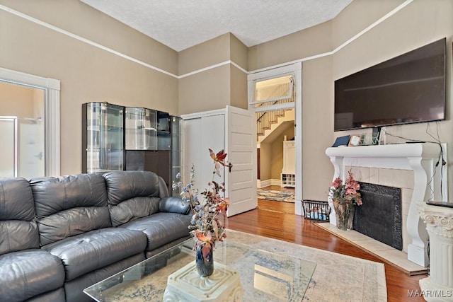 1802 Madison Ave, Montgomery, AL 36107 - living room with wood finished floors, a fireplace, a textured ceiling, and stairway