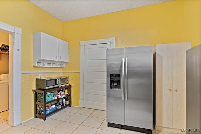 1802 Madison Ave, Montgomery, AL 36107 - kitchen featuring stainless steel appliances, washing machine and dryer, light tile patterned flooring, white cabinets, and a textured ceiling