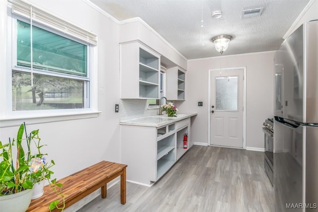 3534 Milan Dr, Montgomery, AL 36109 - kitchen with open shelves, appliances with stainless steel finishes, light countertops, white cabinetry, and light wood-style flooring