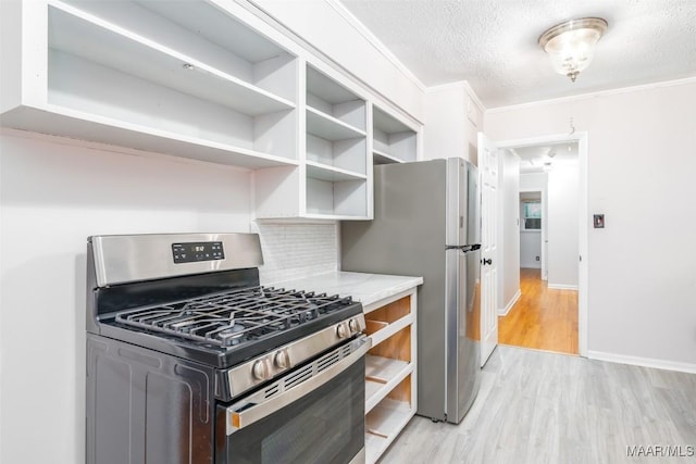 3534 Milan Dr, Montgomery, AL 36109 - kitchen featuring stainless steel appliances, light wood-type flooring, open shelves, a textured ceiling, and tasteful backsplash