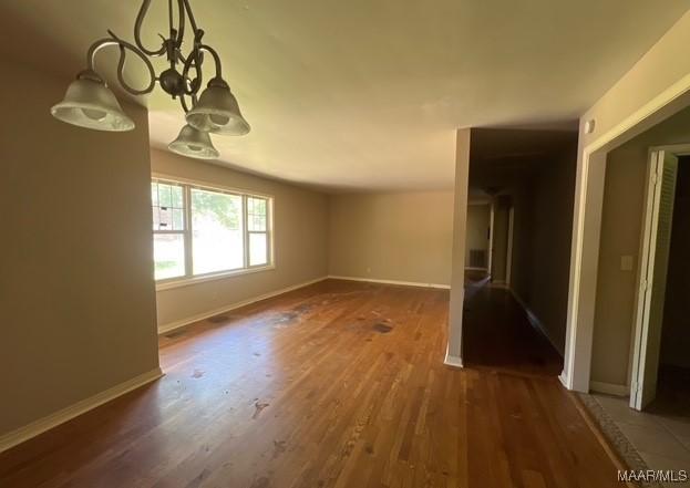 323 E Highland St, Dadeville, AL 36853 - spare room with wood finished floors and a chandelier