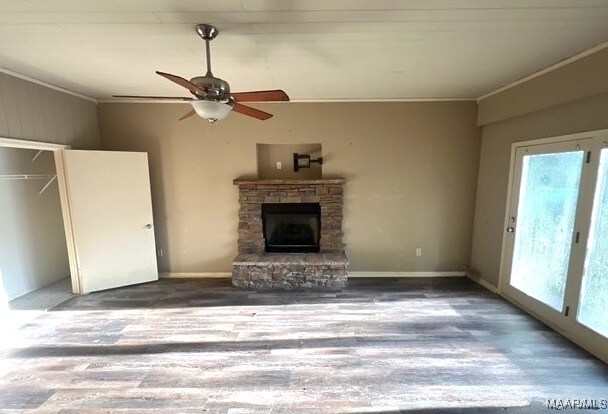 323 E Highland St, Dadeville, AL 36853 - unfurnished living room with ornamental molding, plenty of natural light, a fireplace, a ceiling fan, and wood finished floors