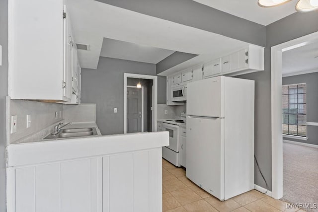508 Ridgewood Ln, Montgomery, AL 36109 - kitchen featuring white appliances, a peninsula, light countertops, light tile patterned floors, and white cabinetry