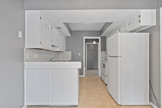 508 Ridgewood Ln, Montgomery, AL 36109 - kitchen featuring freestanding refrigerator, white cabinets, a peninsula, and range