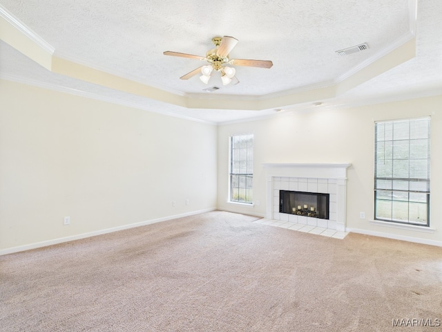508 Mossy Oak Rdg, Prattville, AL 36066 - unfurnished living room with ornamental molding, healthy amount of natural light, a tray ceiling, a tile fireplace, and carpet