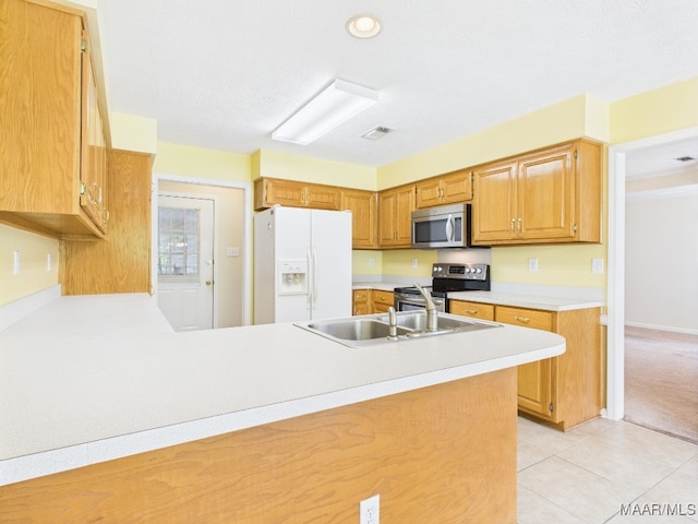 508 Mossy Oak Rdg, Prattville, AL 36066 - kitchen featuring appliances with stainless steel finishes, light countertops, a peninsula, light tile patterned flooring, and brown cabinets