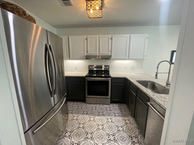 1061 Stonegate Dr Unit C, Auburn, AL 36832 - kitchen featuring stainless steel appliances, under cabinet range hood, white cabinetry, and decorative backsplash