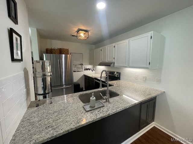 1061 Stonegate Dr Unit C, Auburn, AL 36832 - kitchen with freestanding refrigerator, light stone counters, backsplash, and a peninsula