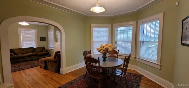 1928 Winona Ave, Montgomery, AL 36107 - dining space with arched walkways, wood finished floors, ornamental molding, and healthy amount of natural light
