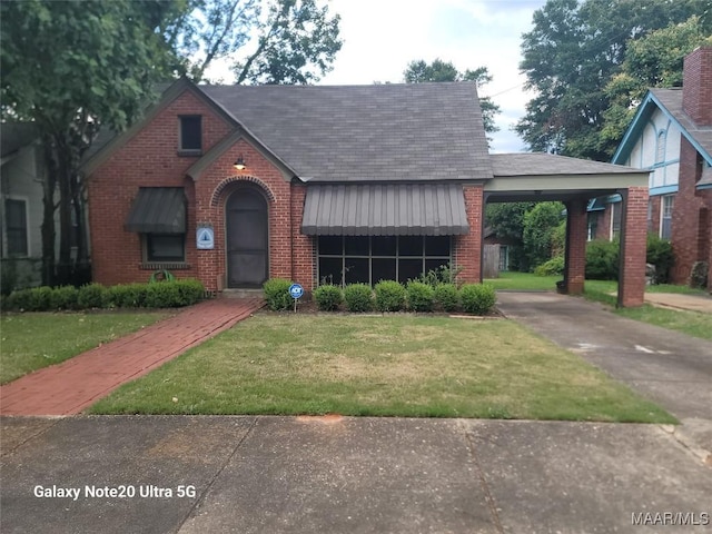 1928 Winona Ave, Montgomery, AL 36107 - english style home with concrete driveway, brick siding, a front yard, and a carport