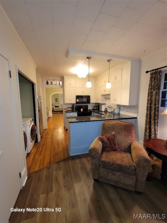 1928 Winona Ave, Montgomery, AL 36107 - kitchen with black microwave, dark countertops, range, and white cabinetry
