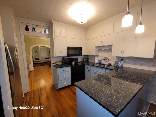 1928 Winona Ave, Montgomery, AL 36107 - kitchen with black appliances, dark wood-style floors, white cabinets, arched walkways, and ornamental molding