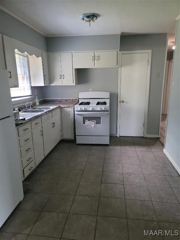 5118 Greensboro Dr, Montgomery, AL 36108 - kitchen with white appliances, white cabinets, dark tile patterned flooring, and dark countertops