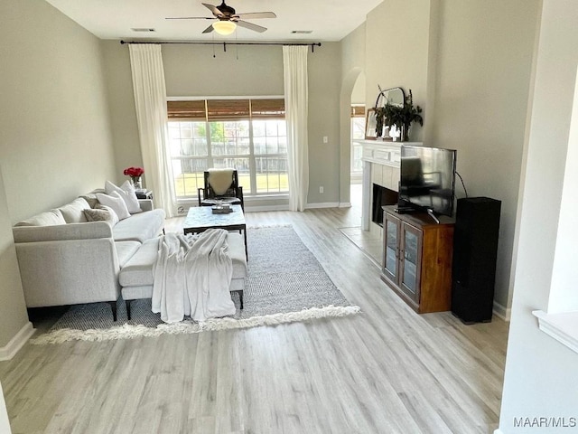 2495 Chancellor Ridge Rd, Prattville, AL 36066 - living area with a ceiling fan, arched walkways, wood finished floors, and a fireplace with flush hearth