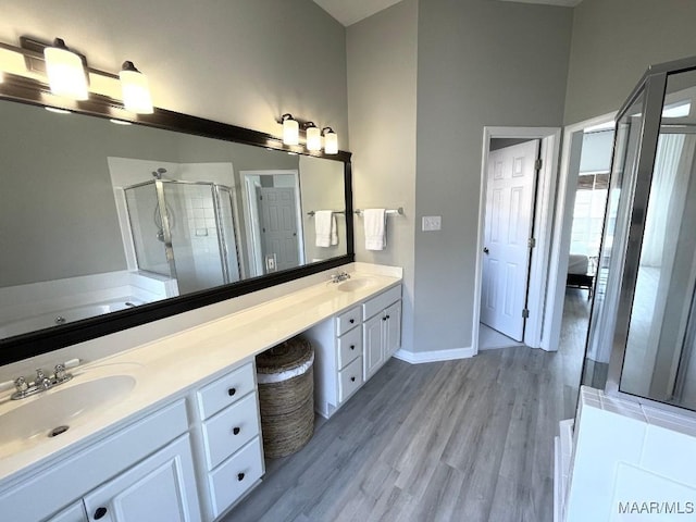 2495 Chancellor Ridge Rd, Prattville, AL 36066 - bathroom with double vanity, a shower stall, a bath, and wood finished floors
